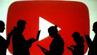 FILE PHOTO: Silhouettes of laptop and mobile device users are seen next to a screen projection of the YouTube logo in this picture illustration taken March 28, 2018. REUTERS/Dado Ruvic/Illustration/File Photo