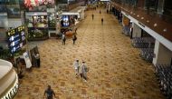 People, some of them wearing protective face masks, walk at Singapore's Changi Airport, following the outbreak of the coronavirus disease (COVID-19) March 30, 2020. REUTERS/Edgar Su