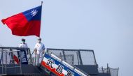 Two navy soldiers stand next to a Taiwanese flag as they welcome members of the public during a visit on the French-built ROCS Wu Chang (PFG-1207) frigate ahead of the National Day celebration in Kaohsiung, Taiwan, October 9, 2021. Reuters/Ann Wang