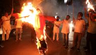 Protestors burn an effigy of Yogi Adityanath, CM of Uttar Pradesh, during a protest after people were killed when a car linked to a federal minister ran over farmers protesting against controversial farm laws in Uttar Pradesh on Sunday, in Kolkata, India,