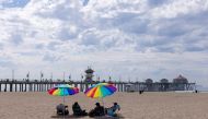 Beachgoers relax in the sand a long way from the water when authorities closed access after a major oil spill off the coast of California came ashore in Huntington Beach, California, U.S. October 4, 2021. Reuters/Mike Blake/File Photo