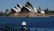 A person in protective face mask walks along the harbour waterfront across from the Sydney Opera House during a lockdown to curb the spread of coronavirus disease (COVID-19) outbreak in Sydney, Australia, October 6, 2021. REUTERS/Loren Elliott/File Photo