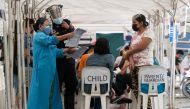 A health worker checks the documents of a child scheduled to be inoculated with Pfizer-BioNTech vaccine against the coronavirus disease (COVID-19), during the vaccine rollout for children with comorbidities, in Pasig, Metro Manila, Philippines, October 15