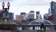 A lone woman, wearing a protective face mask, walks across a city centre bridge as the state of Victoria looks to curb the spread of a coronavirus disease (COVID-19) outbreak in Melbourne, Australia, July 16, 2021. REUTERS/Sandra Sanders/File Photo