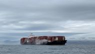 Smoke rises from the container ship Zim Kingston, burning from a fire on board, off the coast of Victoria, British Columbia, Canada October 23, 2021. Canadian Coast Guard/Handout via Reuters
