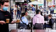 Diners eat outside a cafe in St Kilda while police stand by due to a Victorian Freedom Movement protest on the second day of eased coronavirus disease (COVID-19) regulations in Melbourne, Australia, October 23, 2021. Reuters/Sandra Sanders