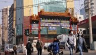 People wearing face masks cross a street in Beijing, following outbreaks of the coronavirus disease (COVID-19) in China, October 25, 2021. REUTERS/Thomas Peter