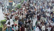Supporters of the banned Islamist political party Tehrik-e-Labaik Pakistan (TLP) stand atop of a vehicle while others walk during a protest, in Lahore, Pakistan, October 23, 2021. Reuters/Mohsin Raza/File Photo