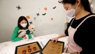 Lee Jin-sun, store owner, and Hwang Hye-won, student, make dog cookies based on the Netflix series 'Squid Game' at a pet store in Seoul, South Korea, October 26, 2021. REUTERS/ Heo Ran/File Photo