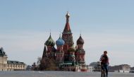 FILE PHOTO: A man rides a bicycle along empty Red Square near St. Basil's Cathedral in central Moscow, Russia May 1, 2020. REUTERS/Shamil Zhumatov/File Photo