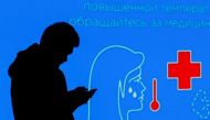 A man uses a mobile phone in front of an electronic screen informing of anti-COVID measures, after new restrictions were imposed by local authorities to curb the spread of the coronavirus disease (COVID-19), in central Moscow, Russia October 28, 2021. REUTERS/Maxim Shemetov/File Photo