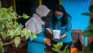 Volunteers of the World Mosquitoes Program (WMP) check the Wolbachia mosquito hatchery bucket at a house in Yogyakarta, Indonesia, October 13, 2021. Reuters/Dwi Oblo