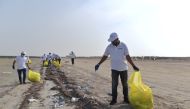 Volunteers collect waste during the clean-up event held at Al Jamail coastline.