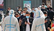 Workers in protective suits inspect the health information of passengers leaving Yantai Railway Station following the recent outbreak of the coronavirus disease (COVID-19), in Yantai, Shandong province, China November 2, 2021. China Daily via REUTERS