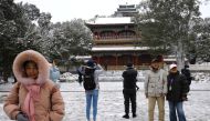 People enjoy snowfall at Jingshan Park, in Beijing, China November 7, 2021. REUTERS/Tingshu Wang