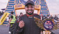 Qatar’s Ahmed Al Amri celebrates with the Red Bull Car Park Drift 2021 winner's trophy at the Al Manara Arena in Cairo, Egypt.
