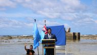 Tuvalu's Minister for Justice, Communication & Foreign Affairs Simon Kofe gives a COP26 statement while standing in the ocean in Funafuti, Tuvalu November 5, 2021. Courtesy Tuvalu's Ministry of Justice, Communication and Foreign Affairs / Social Media via Reuters