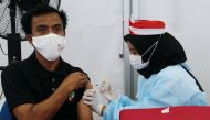 A man receives a dose of a vaccine against the coronavirus disease (COVID-19) during a vaccination program in Jakarta, Indonesia, August 16, 2021. REUTERS/Ajeng Dinar Ulfiana/File Photo