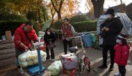People buy cabbage at a street stall, an annual tradition in winter that has taken on extra importance after the government advised people to keep enough basic goods at home in case of emergencies, following outbreaks of the coronavirus disease (COVID-19) in Beijing, China, November 4, 2021. REUTERS/Thomas Peter
