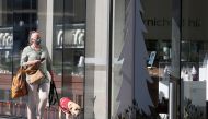 A pedestrian wearing a face mask walks past a storefront as shoppers return to the Newmarket retail district in the wake of coronavirus disease (COVID-19) lockdown restrictions being eased in Auckland, New Zealand, November 10, 2021. REUTERS/Fiona Goodall