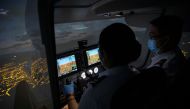 Cadet Casey Abadilla, a flight student, operates a flight simulator beside an instructor, both wearing masks for protection against the coronavirus disease (COVID-19), at the Alpha Aviation Group campus in Clark, Pampanga province, Philippines, November 3, 2021. REUTERS/Eloisa Lopez