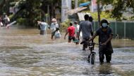 People wade along a flooded road after a heavy rainfall in Kochchikade, Sri Lanka November 11, 2021. REUTERS/Dinuka Liyanawatte