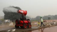 A worker is seen next to an anti-smog gun near the ongoing redevelopment project on Rajpath, on a smoggy day in New Delhi, India, November 12, 2021. REUTERS/Anushree Fadnavis