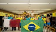 Brazil players and officials celebrate with Qatar and Brazil flags after qualifying for the 2022 FIFA World Cup following their 1-0 win over Colombia. Pic: Twitter/ @CBF_Futebol