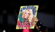 A supporter of singer Britney Spears holds up a picture of the pop star with the words 