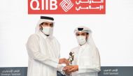 Minister of Commerce and Industry H E Sheikh Mohammed bin Hamad bin Qassim Al Abdullah Al Thani presents the commemorative shield to QIIB’s Head of Development and Alternative Channels Department Omar Abdelaziz Al Meer, during the ceremony, in Doha, recently.  