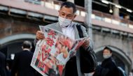 A man reads an extra edition of a newspaper, reporting Japan's Shohei Ohtani of the Los Angeles Angels was named Most Valuable Player of Major League Baseball's American League, in Tokyo, Japan November 19, 2021. REUTERS/Issei Kato