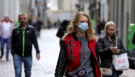 People with and without protective masks walk on the street while shopping as the spread of coronavirus disease (COVID-19) continues in Amsterdam, Netherlands October 7, 2020. Reuters/Eva Plevier/File Photo