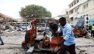 A civilian walks past the wreckages of vehicles and the debris of classrooms after a car exploded in a suicide attack near Mucassar primary and secondary school in Hodan district of Mogadishu, Somalia November 25, 2021. Reuters/Feisal Omar
 