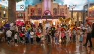 Officials with children celebrating fun day at KidZania Doha.