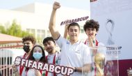 Fans pose with the FIFA Arab Cup Qatar 2021 trophy. 