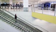 A flight crew member stands on an escalator in the international terminal at Sydney Airport, as countries react to the new coronavirus Omicron variant amid the coronavirus disease (COVID-19) pandemic, in Sydney, Australia, November 30, 2021. REUTERS/Loren Elliott