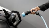 A woman holds a cable to charge a Renault Kangoo ZE electric utility vehicle at a Renault dealership in Cagnes-Sur-Mer, France, October 22, 2020. REUTERS/Eric Gaillard/File Photo/File Photo