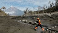 A rescue worked jumps across the lava flow path during an operation at an area affected by the eruption of Mount Semeru volcano, in Curah Kobokan, Pronojiwo district, Lumajang, East Java province, Indonesia, December 8, 2021. REUTERS/Willy Kurniawan