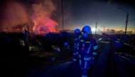 Firefighters walk amidst remains of houses which were burned following the spread of a wildfire in Castro area, in Chiloe, Chile, December 10, 2021. REUTERS/Alvaro Vidal