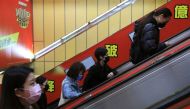 People wearing masks to prevent the spread of the coronavirus disease (COVID-19) ride on an escalator during morning rush hour at a subway station in Taipei, Taiwan, November 30, 2021. REUTERS/I-Hwa Cheng

