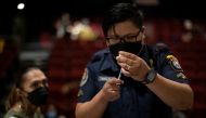 A health worker prepares a dose of COVID-19 vaccine for protection against the coronavirus disease at a cinema turned into a temporary vaccination site in San Juan, Metro Manila, Philippines, December 15, 2021. Reuters/Eloisa Lopez
