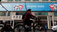 File photo: A man rides a bicycle past the sign of a flagship merchandise store for the Beijing 2022 Winter Olympics in Beijing, China December 8, 2021. Reuters/Carlos Garcia Rawlins