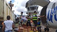 Aviation personnel assist in unloading packs of relief goods for victims of typhoon Rai, in Surigao del Norte province, Philippines, December 18, 2021. Philippine Coast Guard/Handout via Reuters