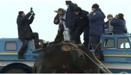 Ground personnel assists Japanese entrepreneur Yusaku Maezawa shortly after landing of the Soyuz MS-20 space capsule in a remote area outside Zhezkazgan, Kazakhstan December 20, 2021, in this still image taken from video. Roscosmos/Handout via Reuters