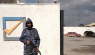 FILE PHOTO: A security officer stands in front of the High National Election Commission building in Benghazi, Libya December 16, 2021. REUTERS/Esam Omran Al-Fetori