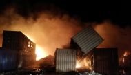 Smoke rises after Syrian state media reported an Israeli missile attack in a container storage area, at Syrian port of Latakia, Syria, in this handout picture released by SANA on December 28, 2021. 