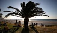 Vistors take in the sunlight at Camps Bay beach as the city experiences a subdued Christmas season after months of lockdowns and worries about the spread of the coronavirus disease (COVID-19) in Cape Town, South Africa, December 23, 2021. REUTERS/Mike Hutchings/File Photo



