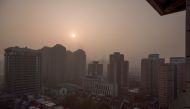 The sun rises over the city on a polluted morning in Beijing, China, November 18, 2021. REUTERS/Thomas Peter

