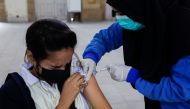 Student Fatima Zakir, 16, reacts as she receives her secound dose of coronavirus disease (COVID-19) vaccine at a vaccination centre in Karachi, Pakistan, January 4, 2022. REUTERS/Akhtar Soomro
