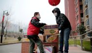 A resident receives free food supplies provided by local government at a residential compound under lockdown, following the coronavirus disease (COVID-19) outbreak in Xian, Shaanxi province, China January 5, 2022. cnsphoto via REUTERS